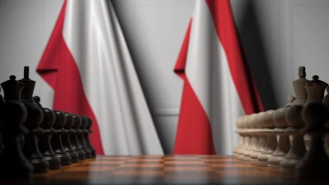 Flags of Poland and Austria behind pawns on the chessboard. Chess game or Stock Footage 116095765
