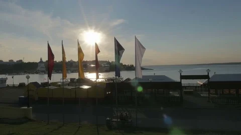 Flags of red, yellow, blue and white color develop in the wind against the Stock Footage 77999954