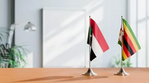 FLAGS OF SUDAN AND ZIMBABWE ON TABLE Stock Photos