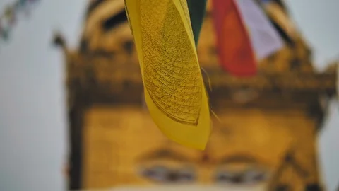 Flags sways, blurred Buddha's eyes on golden stupa in Swayambhunath temple Stock Footage 124676828