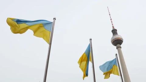 Flags of ukrain blowing in the wind near the tv tower of berlin germany 25fps Stock Footage 186208723