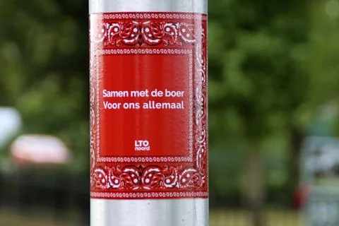 Flags upside down and protest signs on lightning pole in Moordrecht with pr.. Stock Photos