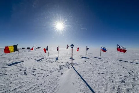 Flags from various countries stand on snow-covered ground at the South Pole, Stock Photos