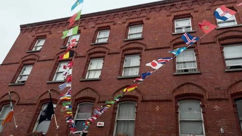 Flags from various countries strung between buildings in Dublin Stock Footage 311771376
