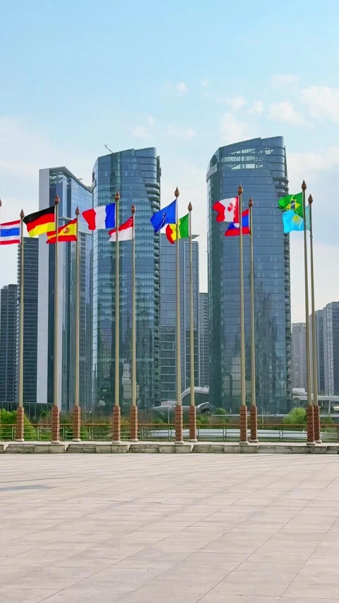 Flags of various nations wave in front of modern skyscrapers. Stock Footage 304879229