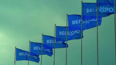 Flags wave at BelExpo in Minsk during a cloudy day as visitors gather for the ev Video stock 338430916