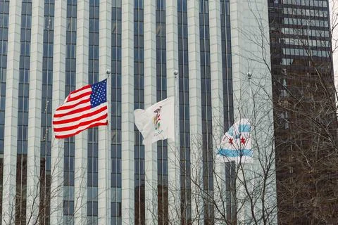 Flags wave in downtown area during a clear day with buildings in the backgrou Stock Photos
