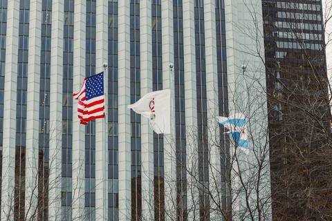Flags wave outside a tall building in a city during a cloudy day Foto stock