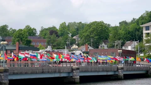 Flags waving on bridge over Saugatuck river in nice cloudy day Stock Footage 156329361