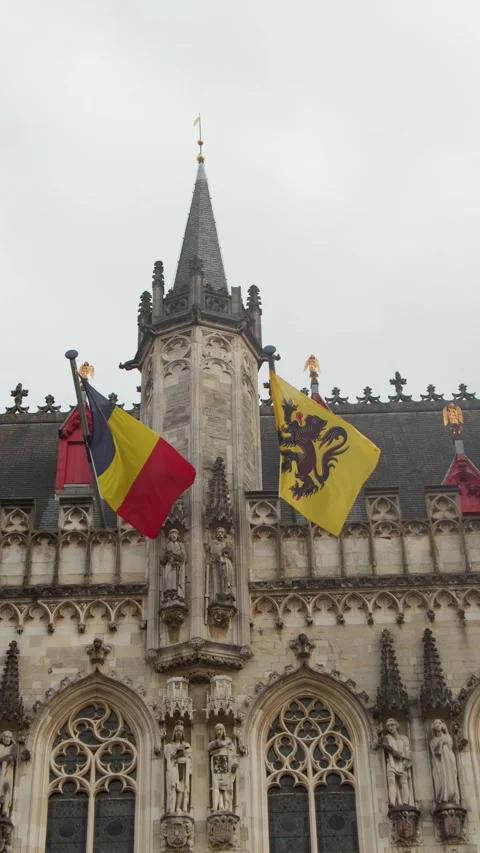 Flags Waving on Historic Gothic Facade in Bruges, Belgium Stock Footage 321718943