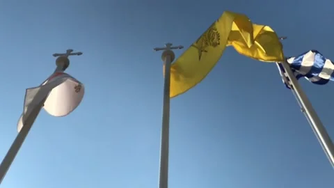 Flags Waving in Low Angle Slow Motion Shot Against Clean Sky Stock Footage 101228156