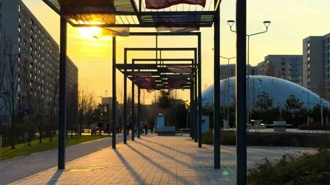 Flags Waving in Park with People Walking at Sunset in Bucharest Stock Footage 331935519