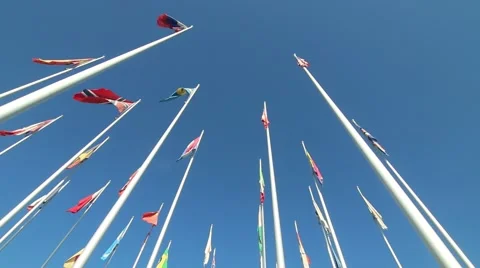Flags waving in the wind with blue sky in background Stock Footage 49976637
