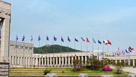 Flags waving in wind with mountain background in front of seoul South Korea war Stock Footage 340358466