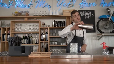 Flair bartending. A handsome young bartender pours a blue curacao liquor  Stock Footage 92535948