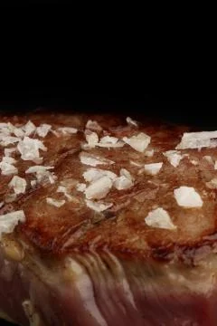Flake salt on a piece of appetizing steak. Close up Stock Photos