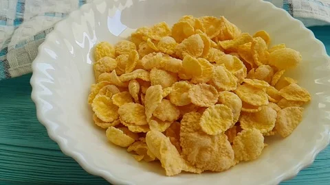Flakes of corn falling in a plate blue wooden, slow-motion Stock Footage 88103895