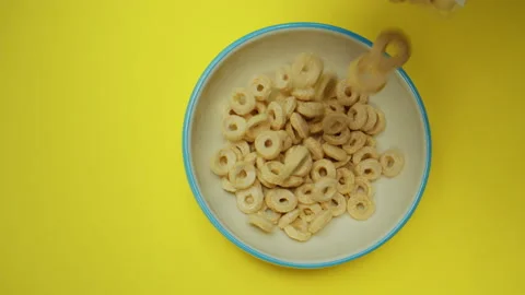 Flakes falling into plate top view on yellow background. Camera laowa. Delicious Stock Footage 139272880