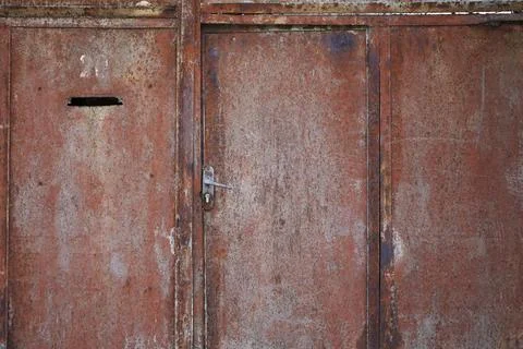 Flaking paint and rust on gates of abandoned building. Stock Photos