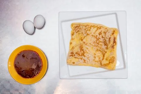 Flaky Egg Prata or egg paratha with Curry Sauce and Fresh Eggs on a White P.. 스톡 사진