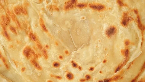 Flaky layers of paratha cooking in a hot pan Vídeo Stock 317735697