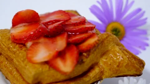 Flaky puff pastry filled with fresh strawberries and strawberry jam on white Stock Footage 344894962