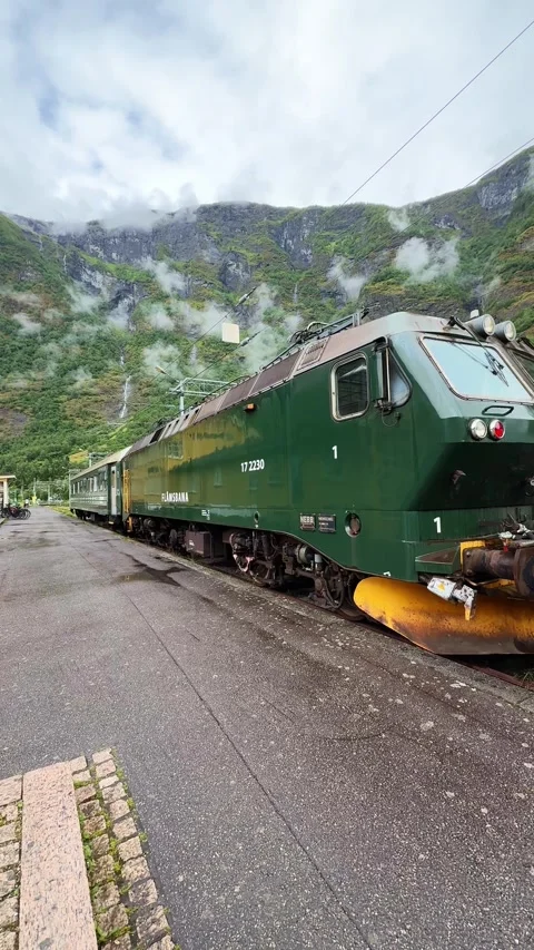 Flam train waiting at station in Norway with mountain view Stock Footage 315031537