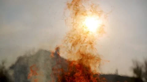 Flame of a bonfire against the background of the sun Stock Footage 89415817