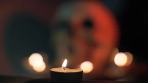 Flame of a burning candle against the background of a blurred skull, Halloween Video stock 96673488