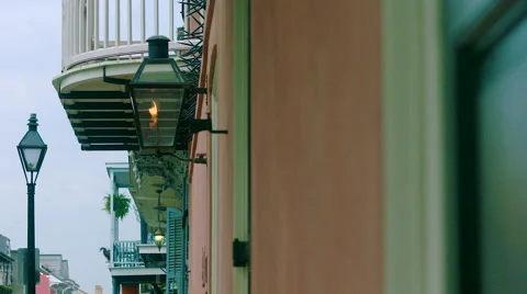 Flame burning, Slo mo, on side of peach building, white balcony behind, French Q Stock Footage 53362956