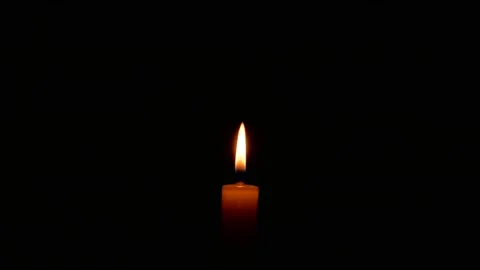 The flame of a burning wax candle in the dark. Stock Footage 144128559