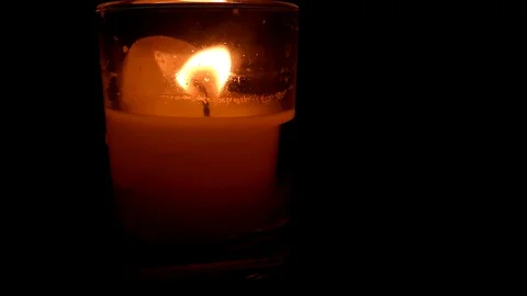 The flame of a candle develops in a glass candlestick, dark Stock Footage 121669264
