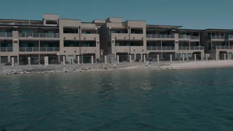 Flame-covered speed boat passes in front of adobe-style luxury condos in the Stock Footage 241498071