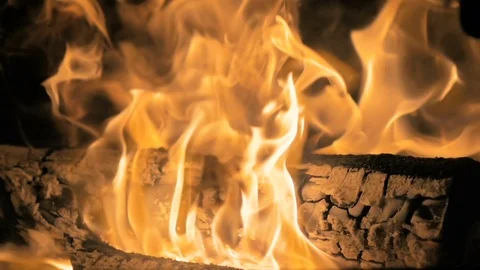 Flame of fire devours the wood logs behind the glass of the home fireplace. Stock Footage 83731764