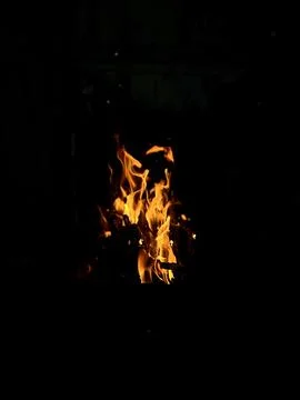 A flame fire on night black background, vertical photo Stock Photos