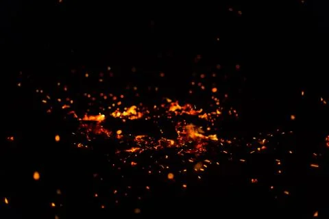 Flame of fire with sparks on a black background Stock Photos