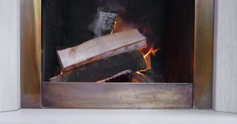 The flame flares up in the fireplace. Fireplace burning wood logs, warm home Stock Footage 201901338