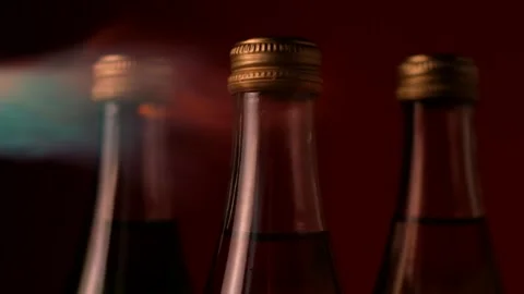 The flame glides over the three glass bottles on the left in the dark Stock Footage 149426067
