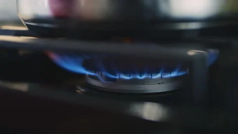 Flame igniting on gas stove in kitchen during cooking preparation Stock Footage 310236732