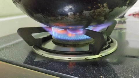 Flame Igniting Under Frying Pan on Kitchen Gas Stove with Selective Focus Stock Footage 321384435