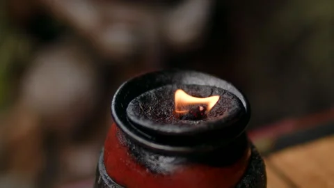 The flame of a lamp against the background of a blurred nature, oil ritual lamp Stock Footage 275827081