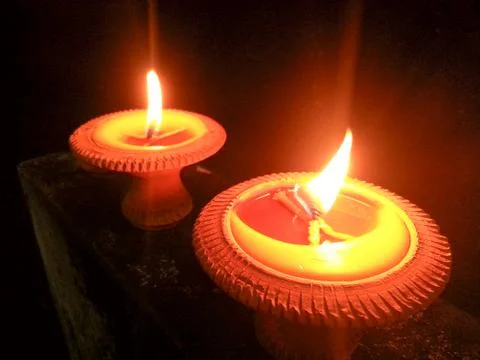 Flame light on small pottery candle base. Stock Photos