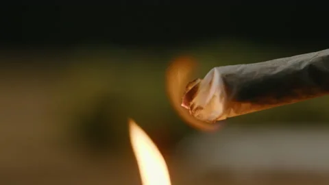 Flame lighting up a rolled marijuana joint Stock Footage 168649593