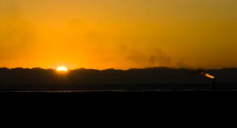 Flame from an oil pipe at sunset. Foto stock