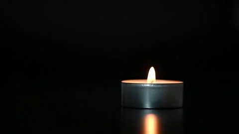 The flame of one candle lights up and goes out on a black background. Stock Footage 229863441