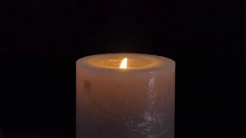The flame of one large gray candle burns and goes out, isolated on a black Stock Footage 220743570