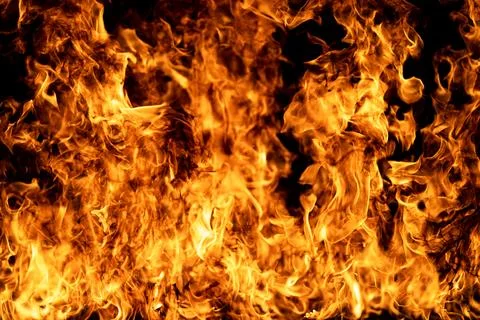Flame rises on black background. Flame texture glows with heat. Realistic flame Stock Photos