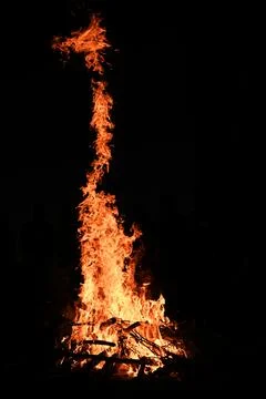 Flame rises vertically at night against deep black background, Stock Photos