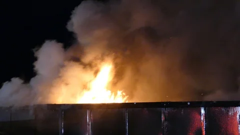 Flame shooting out of rooftop of shiny wall of night club building Stock Footage 129987974