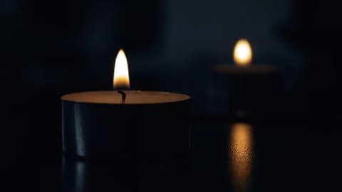 Flame of a small candle in the dark Stock Photos